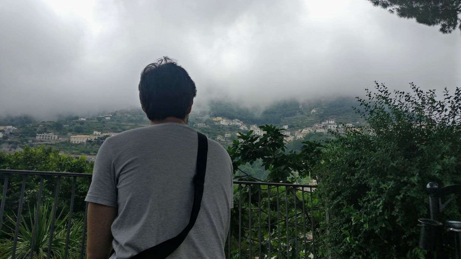 Andrea Palessandro looking across a mountain village beneath low clouds